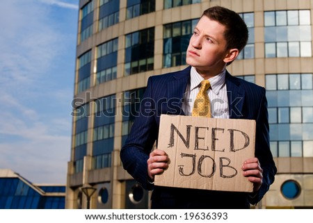 Financial crisis. Unemployment. Young businessman holding sign Need Job outdoors