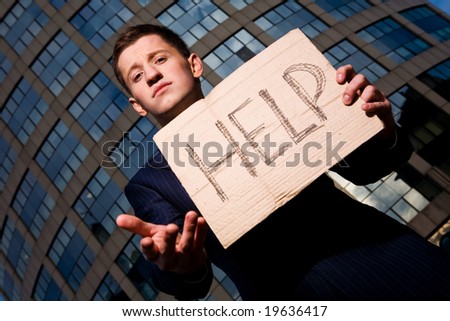 Financial crisis. Unemployment. Businessman holding sign Help outdoors