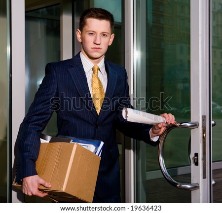 Financial crisis. Unemployed young manager leaving business center in megalopolis