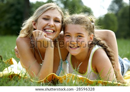Funny mom and daughter smiling outdoors