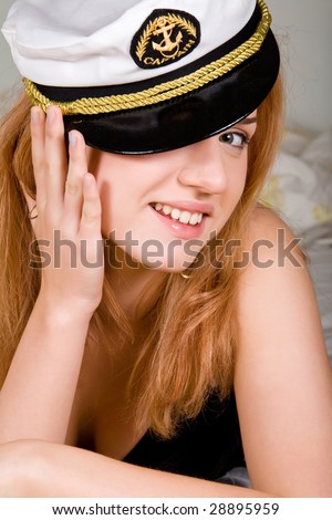 Lovely young woman in bed with a sea peak-cap