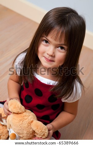 Five year old cute girl holding soft toy indoors