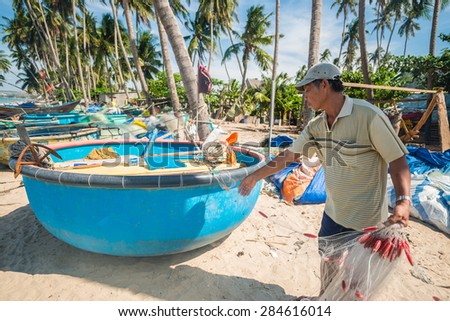 MUI NE, VIETNAM - 23 MAY 2015: Vietnamese fisherman is prepare his fishing net for his break time after back to the shore at Fisherman Village, Mui Ne, Vietnam
