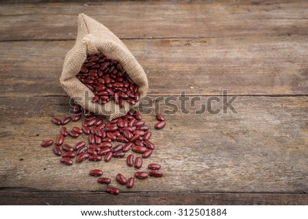 Dried red beans in burlap sack, red beans in burlap bag on old wood panel