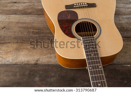 Close up acoustic guitar on old wood panel