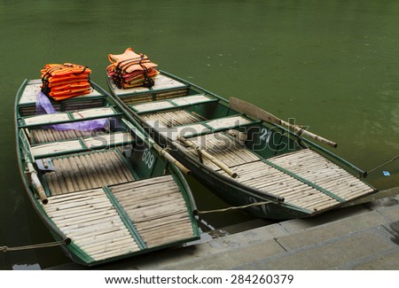 Ninh Binh, Viet Nam - May 16, 2015: Boats waiting for their turns to serve tourists at wharf. This location is very famous and has become a UNESCO heritage site.