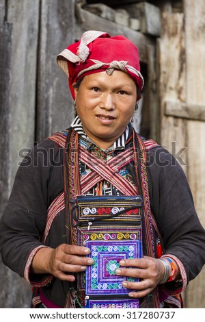 Sapa, Vietnam - Sep 7, 2015: Woman from Red Dao minority group wearing traditional attire and headdress in Sapa, Lao Cai Province, Vietnam.