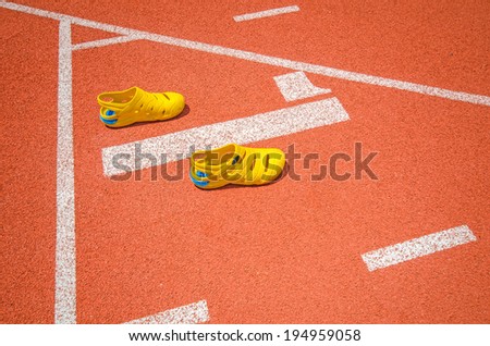 Yellow sport shoes on athletic track