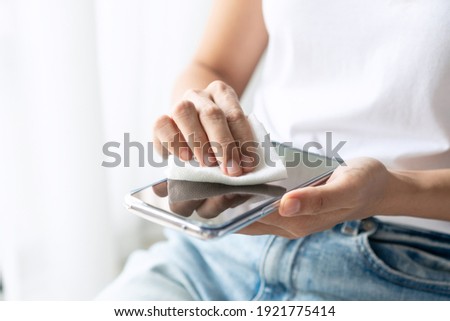 Similar – Image, Stock Photo Woman disinfecting phone with antiseptic wet wipe. Antiseptic napkin to prevent spread of germs, bacteria and coronavirus. Coronavirus prevention. Prevent illness coronavirus after public place.