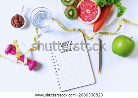 Flat lay of fruits, vegetables, dumbbell ,tape measure and a glass of water on white table background. Clean eating and exercise for good health concept. Top view, copy space