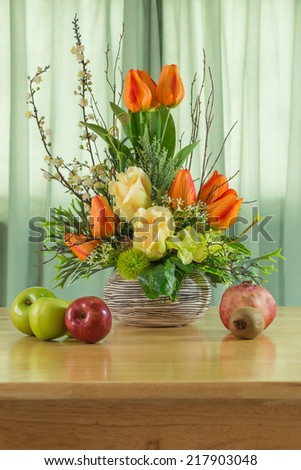 Still life with flowers and fruits on wooden table
