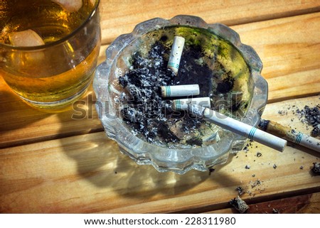 Still life with whiskey and cigarettes on wooden table