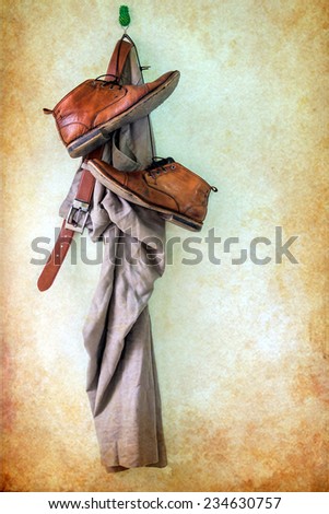 Brown pants and boots hanging over grunge background