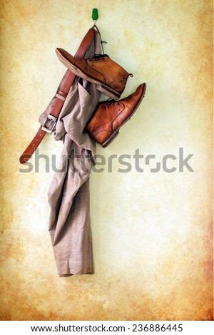Brown pants and boots hanging over grunge background
