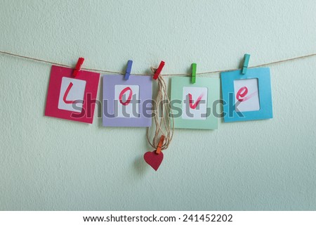 Vintage love write on paper photo frame over wall background, Valentine concept