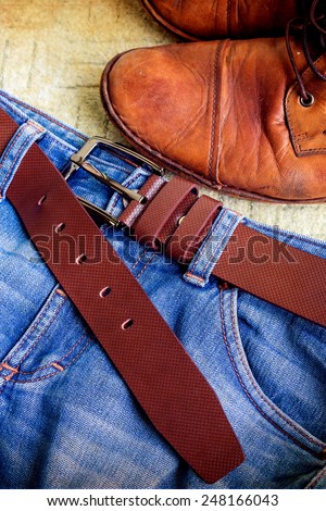 Still life with jeans and boots on green carpet background