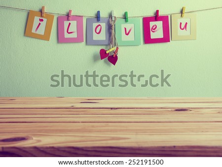 wooden table over vintage i love you write on paper photo frame and red heart over wall background, Valentine concept