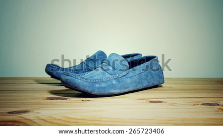 still life with Men\'s Casual Shoes on wooden table over grunge background