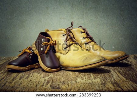 Daddy\'s boots and baby\'s shoes, fathers day concept.