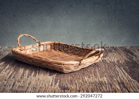 Basket on wooden table over grunge background, rustic style