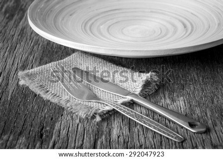 Knife and fork  with plate on wooden dining tables, rustic style, Black and white