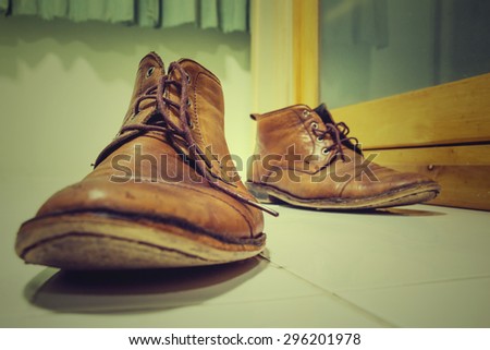Old boots on the floor in dressing room, still life