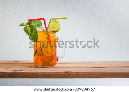 Fresh cocktail with lemon tea on wooden counter bar, rustic style
