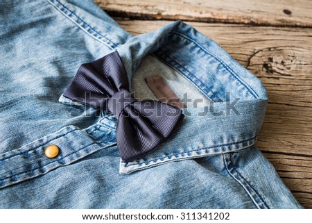Men\'s casual outfits with jeans shirt and bow tie on wooden background