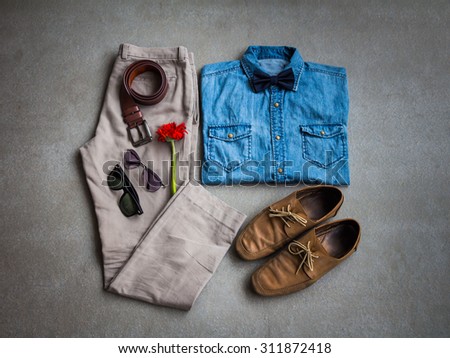 Men's casual outfits, jean shirt with bow tie, brown pants, sunglasses and shoes on gray background