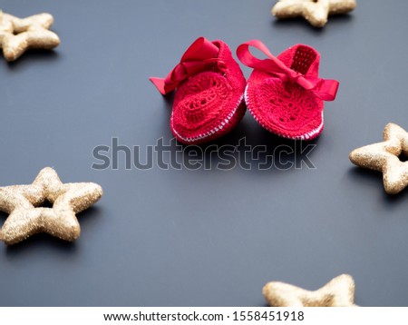 Baby red shoes on a dark grey background decorated with golden stars. Christmas winter theme. New baby announcement concept. Baby shower invitation. Baptism invitation idea. Flat lay top view.  Zdjęcia stock © 