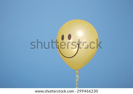Yellow balloon with smile on blue background.Yellow Ribbon