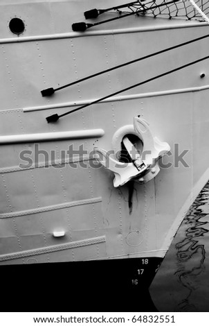 a black and white image of and anchor on a ship tied up in a harbor.