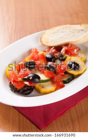 Zucchini salad with tomatoes and olives with bread