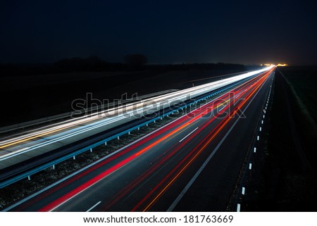 Night highway with car traffic and blurry lights when long exposure
