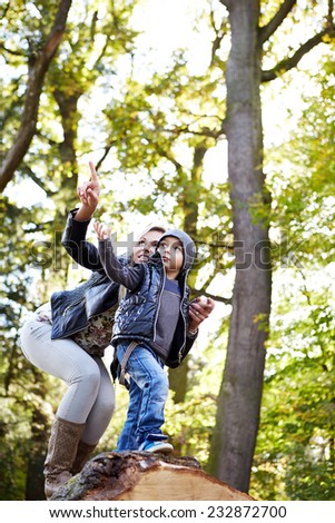 Mother shows her son into the distance in the forest