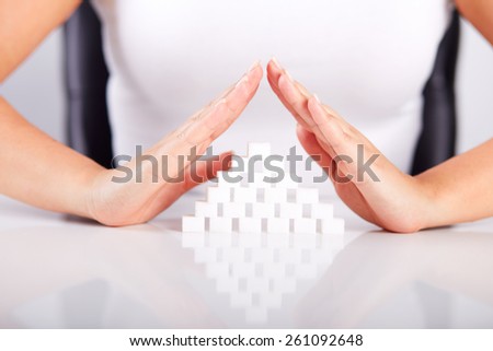 Female hands over a pyramid of sugar cubes