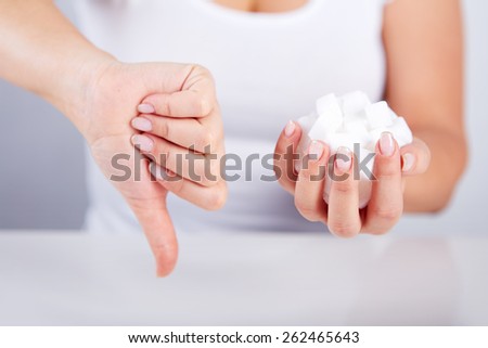 Woman is holding a handful of sugar cubes