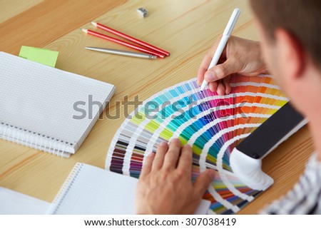 Graphic designer choosing a color from the sampler