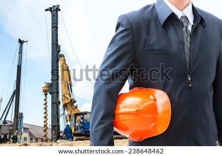 engineer orange helmet for workers security over new houses and crane background