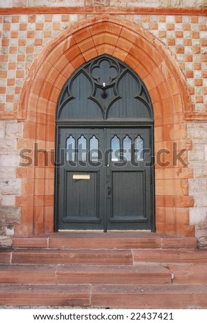 Wooden church door with stone arch doorway
