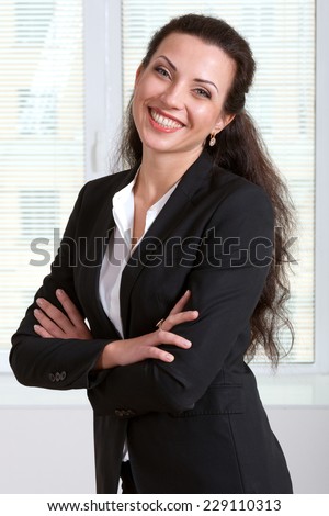 Woman in suit laughs with folded her hands