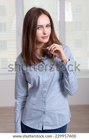 Girl in formal attire took off her glasses looking at camera