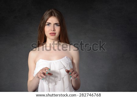 Concept human emotions. Girl showing disgust against a dark background