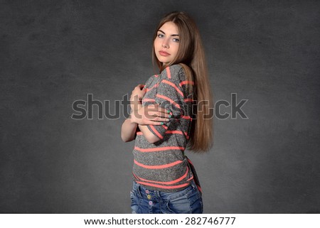 Concept human emotions. Girl shows modesty or timidity against a dark background