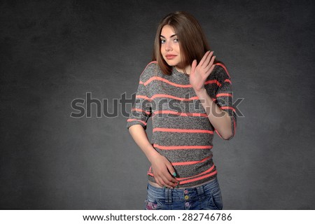Concept human emotions. Girl shows shyness against a dark background