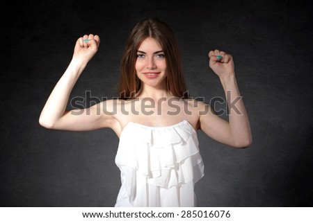 Admiration, joy, victory concept. Woman raised her hands up against a dark gray background