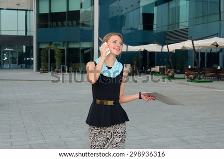Business woman in formal attire happy talking on the phone in the business district of the city