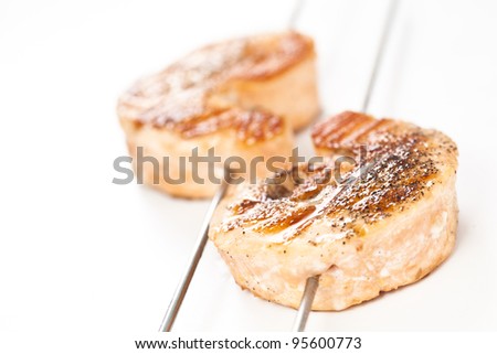 skewer of grilled seasoned salmon isolated over white background