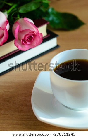 Books, coffee and roses on wooden table