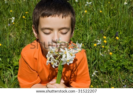 Boy smelling flowers in the meadow